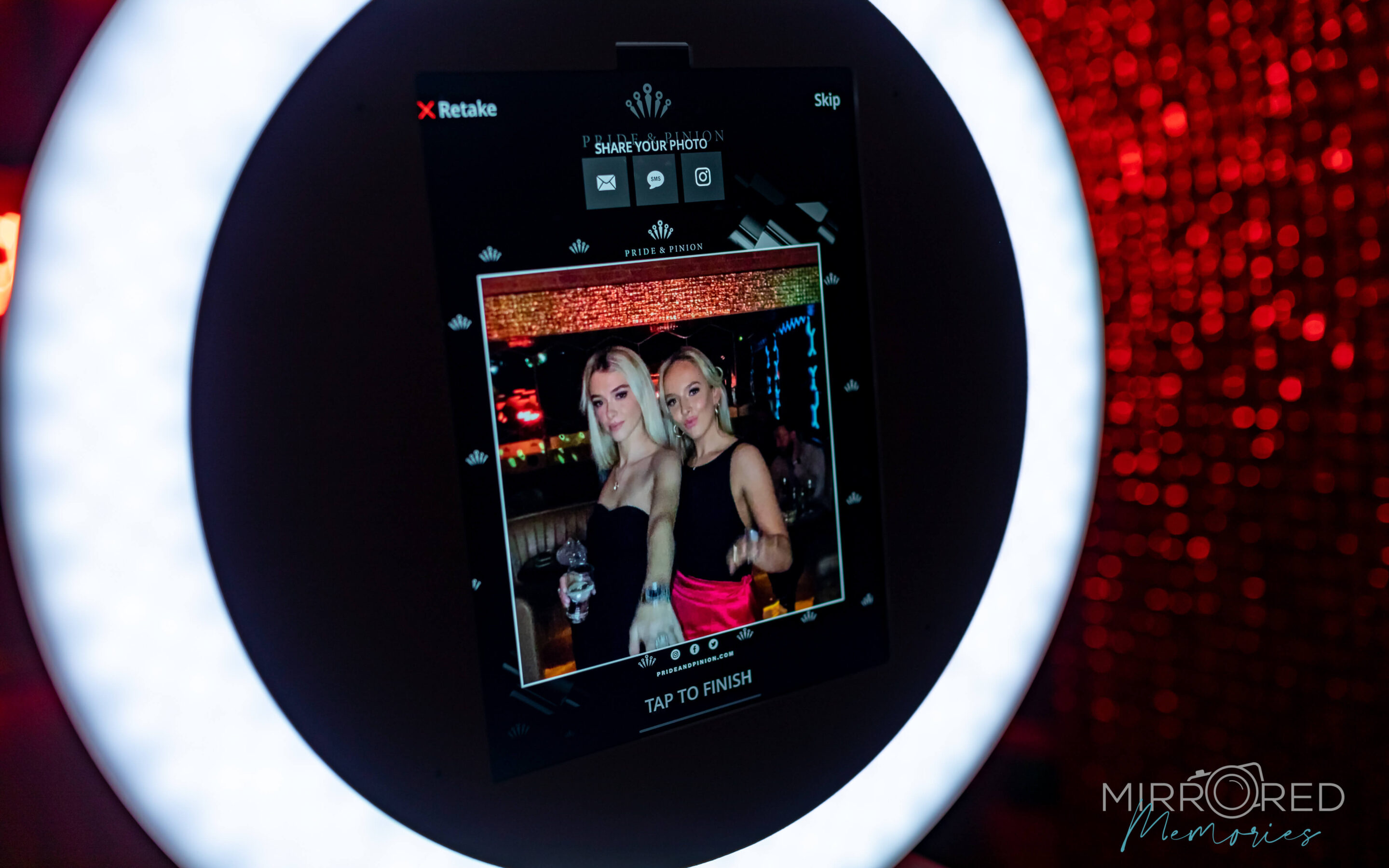 Friends laughing in front of a birthday party selfie booth in San Diego